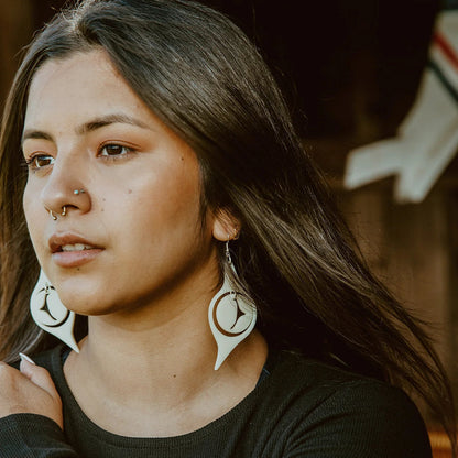 A model wearing ivory acrylic "Octopus Eye" earrings from Copper Canoe Woman.