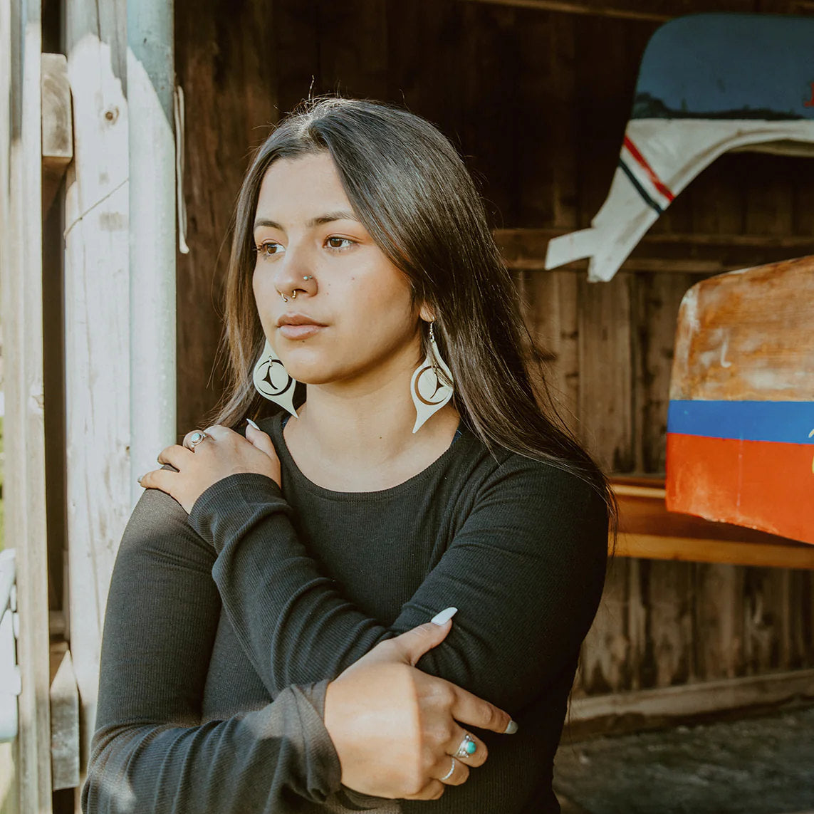 A model wearing a pair of "Octopus Eye" earrings in ivory acrylic from Copper Canoe Woman.