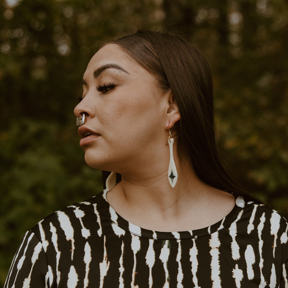 woman wearing ivory acrylic paddle earring with star abalone inlay from copper canoe woman