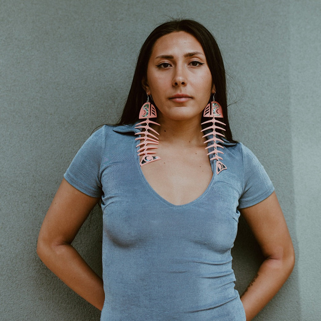 Model wearing matte coral acrylic large salmon ghost earrings from Copper Canoe Woman.