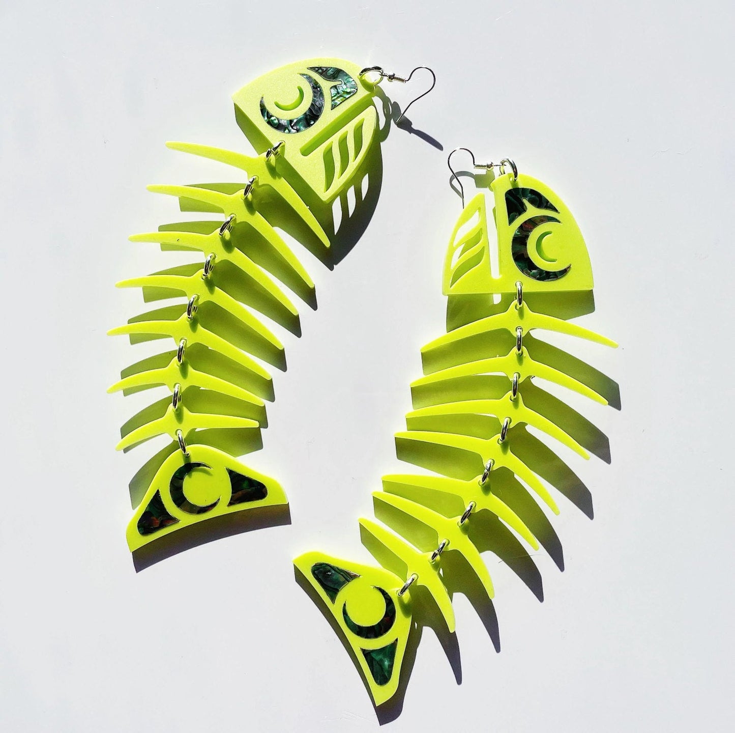 Copper Canoe Woman large salmon ghost earrings in neon pear acrylic.