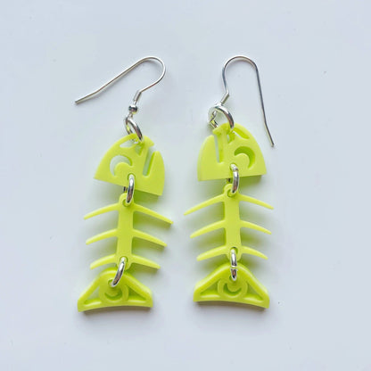 A pair of neon pear acrylic small salmon ghost earrings from Copper Canoe Woman laying on a white background.