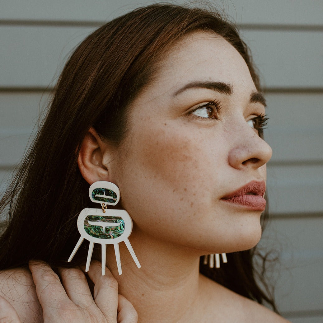 Model wearing Urchin earrings in matte bone acrylic from Copper Canoe Woman.