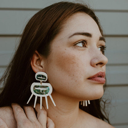 Model wearing Urchin earrings in matte bone acrylic from Copper Canoe Woman.