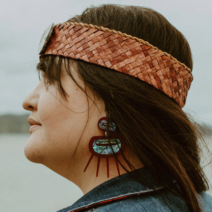 Model wearing Urchin earrings from Copper Canoe Woman in red translucent acrylic.