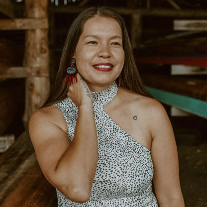 A woman wearing Urchin earrings from Copper Canoe Woman in red translucent acrylic.